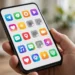 A smartphone showing colorful app icons, several of them greyed out with small cloud-download badges showing they have been offloaded