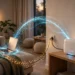 A home Wi-Fi router sending a glowing wireless signal toward a laptop on a couch, with a data cable running into the wall — illustrating the difference between Wi-Fi speed and internet speed